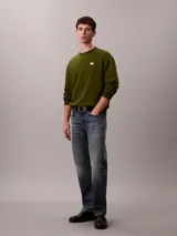 Buzo de cuello redondo Calvin Klein confeccionado en algodón regenerado de color verde militar, con interior de tejido terry, puños y cuello con punto canalé, y un pequeño parche con el monograma de la marca en el pecho.