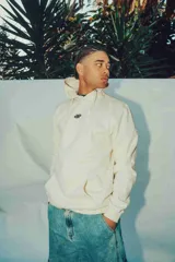 Hoodie color crema de corte oversize con capucha y logo pequeño en el pecho.