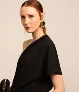 Blusa negra de crepé con un solo hombro, escote drapeado y manga corta.