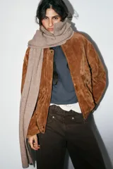 Bufanda de punto con cuello alto y cierre frontal con cremallera, diseñada con mangas largas integradas.