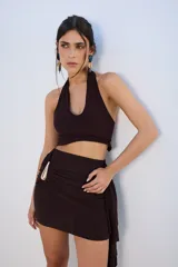 Minifalda marrón con drapeado lateral y detalle de hebilla dorada.