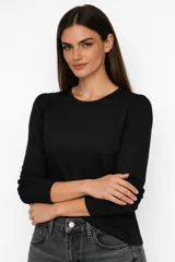 Remera de manga larga con hombros ligeramente abullonados, confeccionada en viscosa, con cuello redondo y corte ajustado.