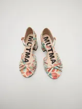 Sandalias de charol color blanco con múltiples tiras finas cruzadas en el empeine. Tienen pulsera con hebilla dorada y tacón cuadrado.