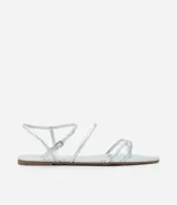 Sandalia plana dorada con tiras finas y cierre con hebilla en el tobillo.