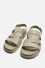 Sandalias negras con tiras anchas, ajuste con hebilla y plantilla anatómica. Suela plana a tono.