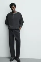Pantalón de corte recto confeccionado en tejido compacto de algodón con estructura twill. Presenta cierre frontal con cremallera y botón, bolsillos laterales y bolsillos traseros de vivo con botón.