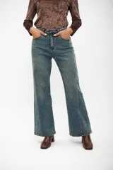 Pantalón de jean corte wide leg, color azul medio, con costuras verticales decorativas en el frente y tiro alto.