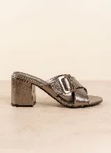 Sandalia de taco ancho color dorado, confeccionada en cuero vacuno, con diseño de tiras cruzadas y hebilla metálica decorativa.