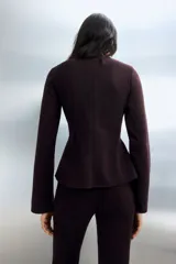 Top de punto fino levemente cepillado, con cuello alto y mangas largas. Presenta pinzas en la cintura para un efecto entallado y cierre con botones en la parte posterior.