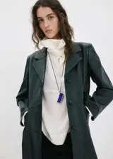 Collar largo con cordón negro ajustable y un dije colgante rectangular con detalles metálicos dorados y resina en tono azul.