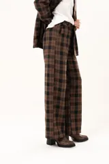 Pantalon de vestir de corte recto y tiro alto, confeccionado en tela con estampado de cuadros en tonos marrones y negros.