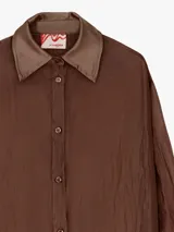 Camisa extra larga y oversize de lyocell color negro, con textura arrugada, cuello camisero y mangas largas con puños de satén.