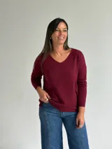 Sweater de punto en color bordó, con escote en V, mangas largas y diseño de corte recto con dobladillo ligeramente más largo en la parte posterior.
