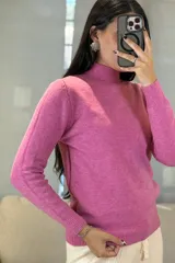 Buzo de tejido de punto color rosa, con cuello alto y puños acanalados.