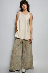 Musculosa de felpa francesa con efecto acid wash, corte en línea A y tirantes ajustables con hebilla en los hombros. Presenta costuras verticales decorativas y bajo acampanado.