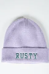 Gorro de lana tejido en canalé color lila, con vuelta y bordado frontal con la inscripción "RUSTY" en color verde y blanco.