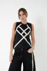 Top de lino 100% color negro con tiras de puntilla de algodón color marfil entrecruzadas formando rombos y puntilla negra en sisas y cuello. Estilo Jackie sin mangas, con cierre de botones en la espalda.