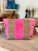 Cartera tipo sobre de cuero con diseño de rayas verticales en tonos verde menta y marrón tostado. Cuenta con detalles de borlas colgantes en los laterales.