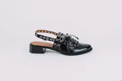 Sueco de cuero negro con cordones, ojales, hebillas y tira trasera regulable con elástico. Tiene taco cuadrado bajo.