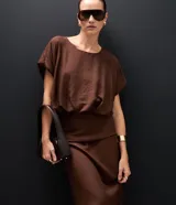 Pollera midi de viscosa color marrón, con diseño de canesú estructurado en la cintura que aporta una división visual y un ajuste definido.