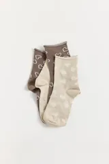 Pack de dos pares de medias cortas con diseño de corazones. Un par es de color marrón con corazones blancos contorneados y el otro par es de color beige con corazones blancos rellenos. Ambas cuentan con el logo de la marca estampado en la planta.