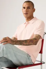 Remera polo Levi's color rosado pálido, confeccionada en tejido piqué, con cuello clásico y cierre frontal de dos botones.
