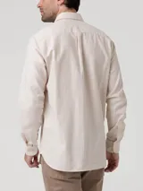 Camisa de manga larga RKF modelo Flasquare, color beige con sutil patrón a cuadros, cuello camisero, cierre frontal con botones y un bolsillo ojal en el pecho con el logo bordado de la marca.