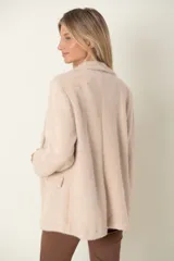 Blazer italiano color beige, de corte recto, con solapas de muesca, cierre de un botón y bolsillos simulados.