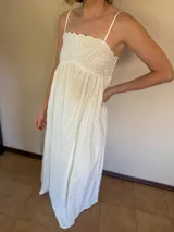 Vestido blanco de algodón con breteles finos y aplique bordado en el busto.