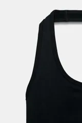 Body de cuello halter confeccionado en tejido rib, con diseño de espalda descubierta y cierre inferior.