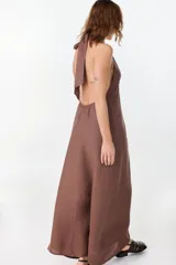 Vestido largo marrón de corte fluido y caída recta, con escote halter y tirantes anchos.