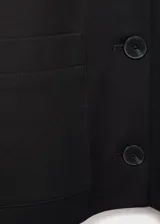 Chaqueta corta de diseño recto con cuello camisero, cierre frontal de botones y dos bolsillos de parche laterales. Presenta manga larga y forro interior.