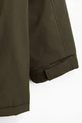 Campera parka acolchada repelente al agua y rompevientos, con cuello alto, capucha ajustable, cierre frontal con solapa y bolsillos frontales tipo parche y calientamanos.