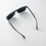 Lentes de sol polarizados con armazón negro mate, formato rectangular envolvente y patillas combinadas en metal gris oscuro y negro.