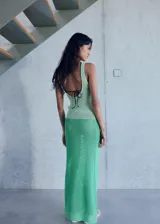 Vestido largo de tejido de punto crochet con diseño bicolor en tonos verde claro y verde vibrante. Presenta cuello caja, tirantes anchos y un corte recto que se ajusta a la silueta.