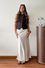 Falda larga color crudo con estampado de lunares negros, de corte al bies y silueta fluida.