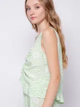 Blusa sin mangas de tela fluida con estampado floral en blanco y negro. Cuenta con jareta para fruncir en la parte delantera central.