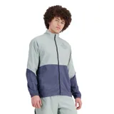 Campera deportiva New Balance Graphic Impact Run Packable, color gris claro y azul marino. Confeccionada en tejido de nailon resistente al viento y al agua, con cierre frontal completo, cuello alto y puños elásticos. Cuenta con un bolsillo plegable que permite guardar la chaqueta en una riñonera.