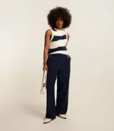 Pantalón de vestir azul marino, de corte recto, con pinzas delanteras, bolsillos laterales y traseros. Se ajusta a la cintura con cierre invisible y trabillas para cinturón.