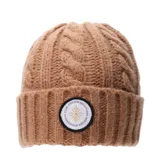 Gorro tipo beanie de punto trenzado en color verde grisáceo, con vuelta y parche circular frontal con diseño gráfico y texto.