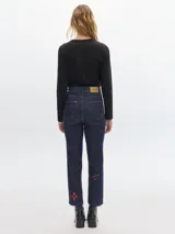 Pantalón de jean negro con corte recto, tiro alto y bolsillos delanteros con bordado de estrella verde.