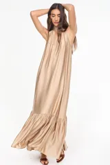 Vestido largo color tostado de viscosa, con cuello halter alto, diseño holgado y volante fruncido en el bajo.