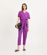 Pantalón pantacourt color violeta con cintura elástica, lazo en la cintura, bolsillos con botones y textura airflow.
