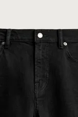Jeans slim fit de color negro para hombre, con tiro medio, diseño de cinco bolsillos y cierre frontal con cremallera y botón.