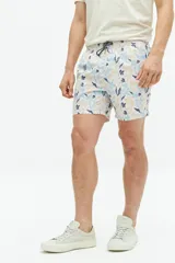 Short de baño con estampado floral en tonos beige, azul y negro. Cuenta con cintura elástica con cordón ajustable, dos bolsillos laterales y uno trasero, confeccionado en tejido ligero de secado rápido.