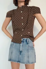 Falda pantalón de tiro medio confeccionada en denim, con bolsillos delanteros y cierre frontal con cremallera y botón metálico.