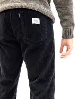 Pantalon de pana negra con textura acanalada, corte recto y diseño de cinco bolsillos.