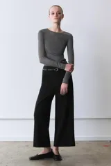 Pantalón culotte negro de tiro medio con trabillas y cinturón fino efecto piel con hebilla metálica. Presenta raya planchada y cierre de cremallera oculta en la costura.