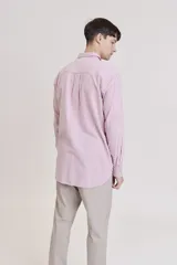 Camisa de manga larga, color rosa claro con finas rayas verticales blancas, cuello camisero y un bolsillo en el pecho.