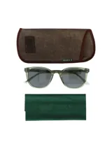 Lentes de sol con montura redonda color verde y lentes grises.